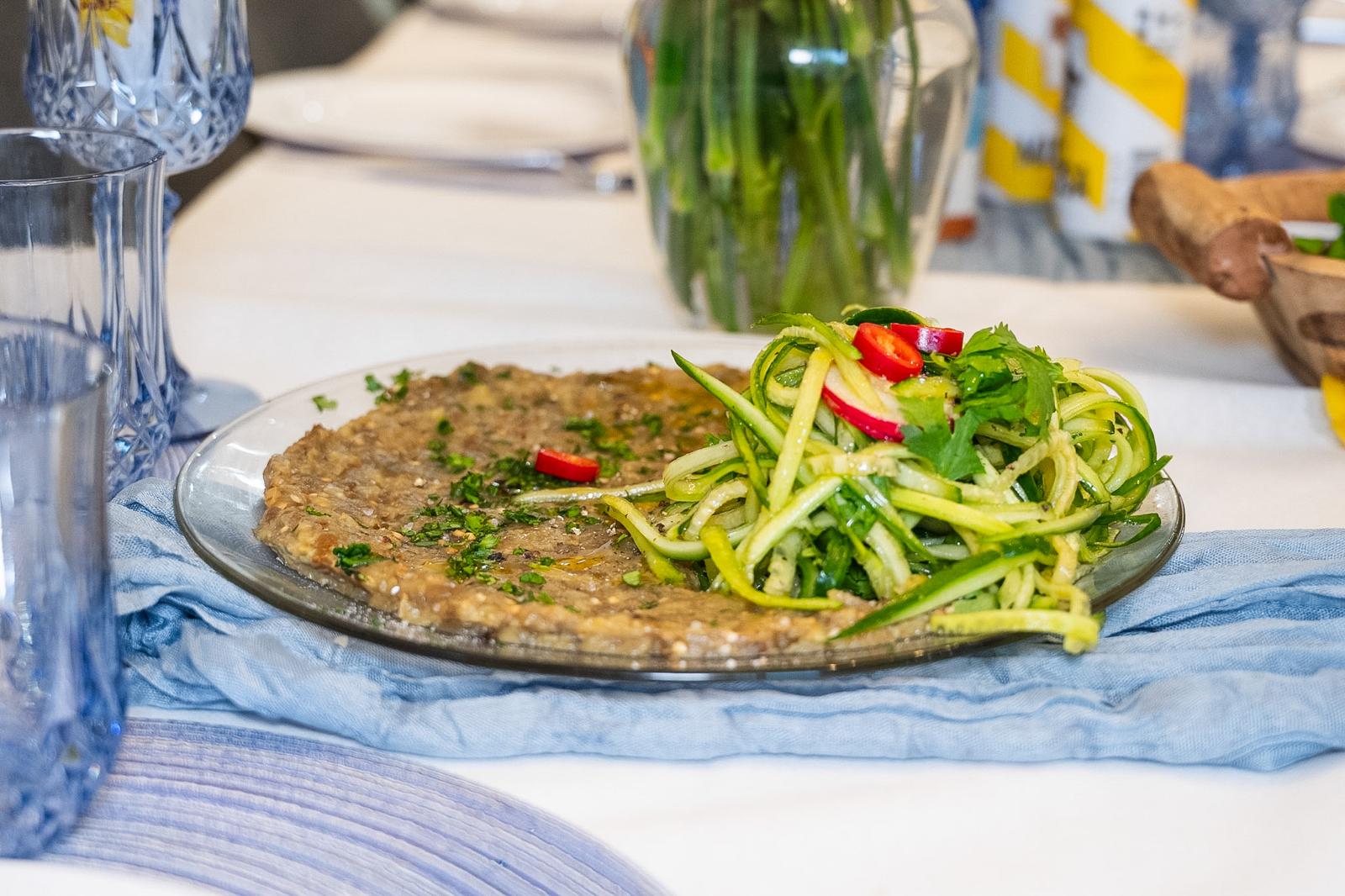 A composed vegetable dish with fresh zucchini ribbons